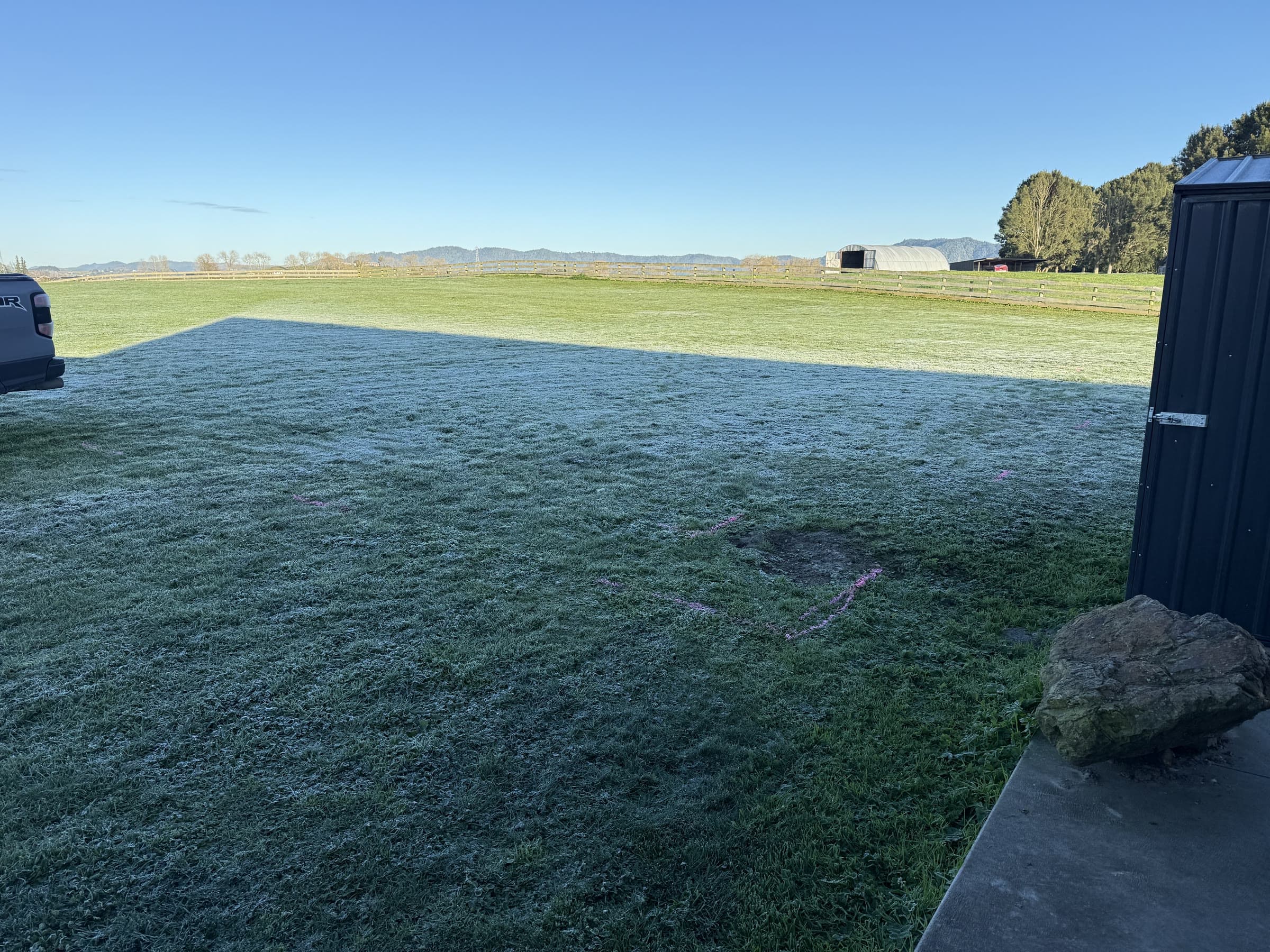 House site marked out in paint on a frosty morning, open farmland behind