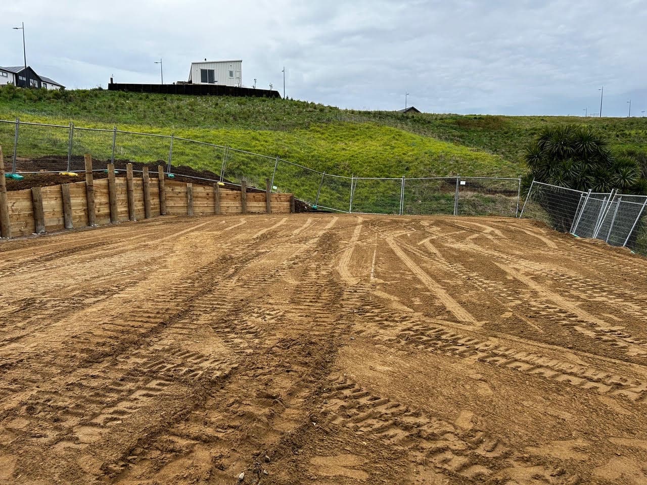 Levelled and compacted house site with a new timber retaining wall along the back boundary