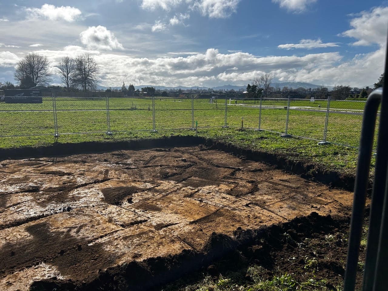 Topsoil stripped back to clay for a building footprint on a fenced subdivision section